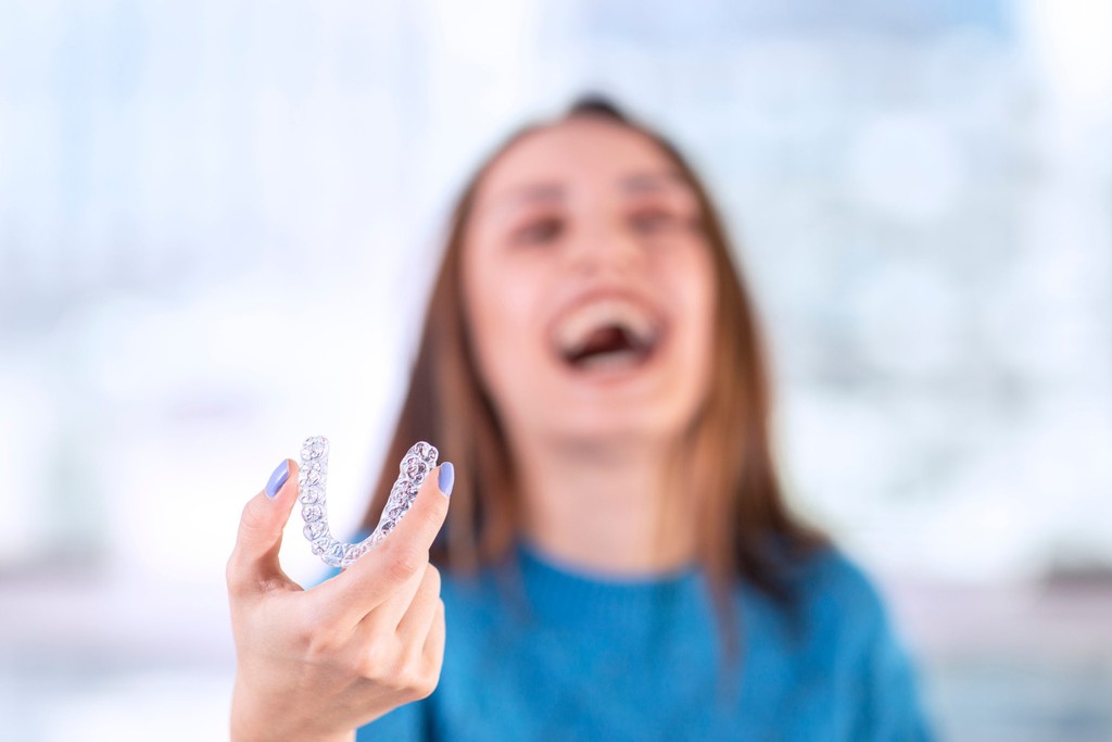 Woman Happy Holding Invisalign Aligner
